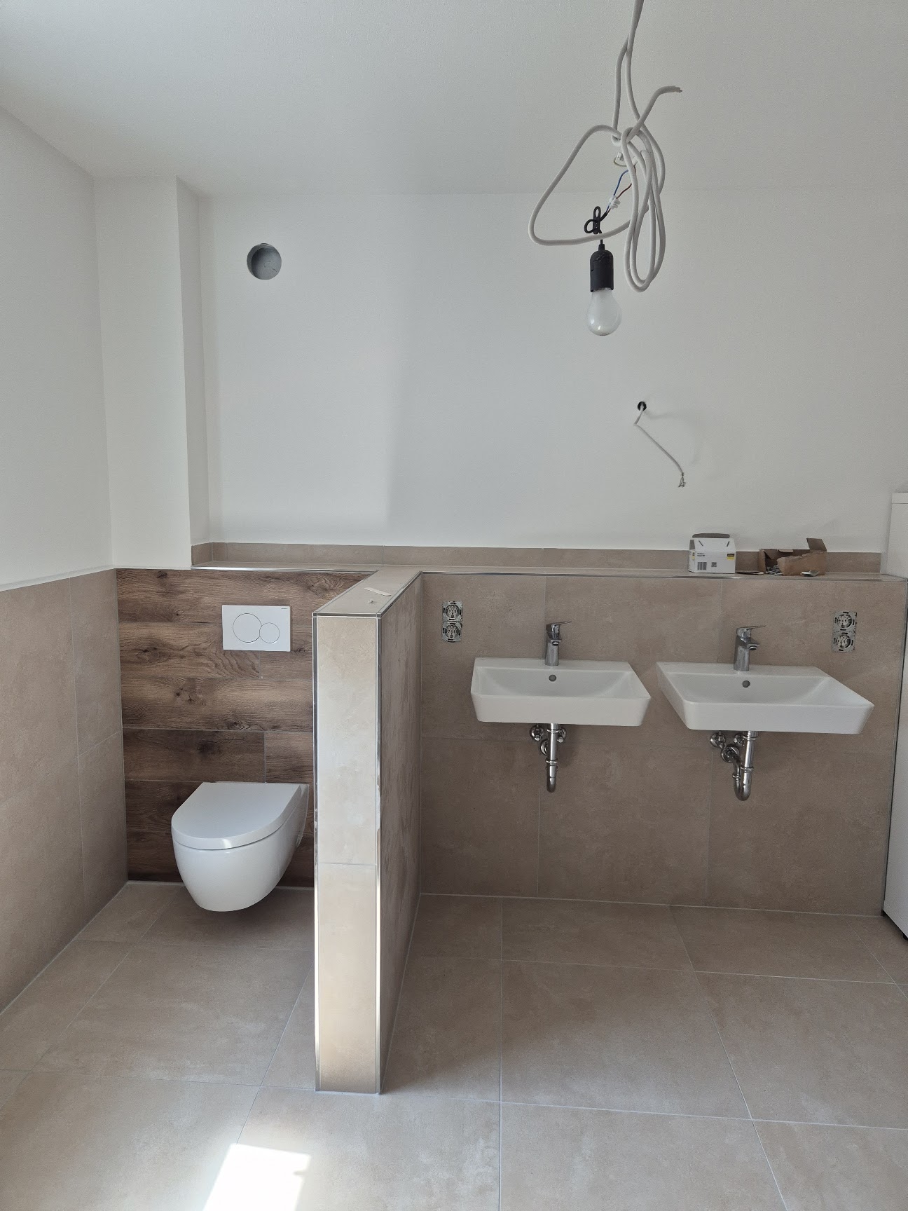 Badezimmer mit Doppelwaschtisch und wandhängendem WC