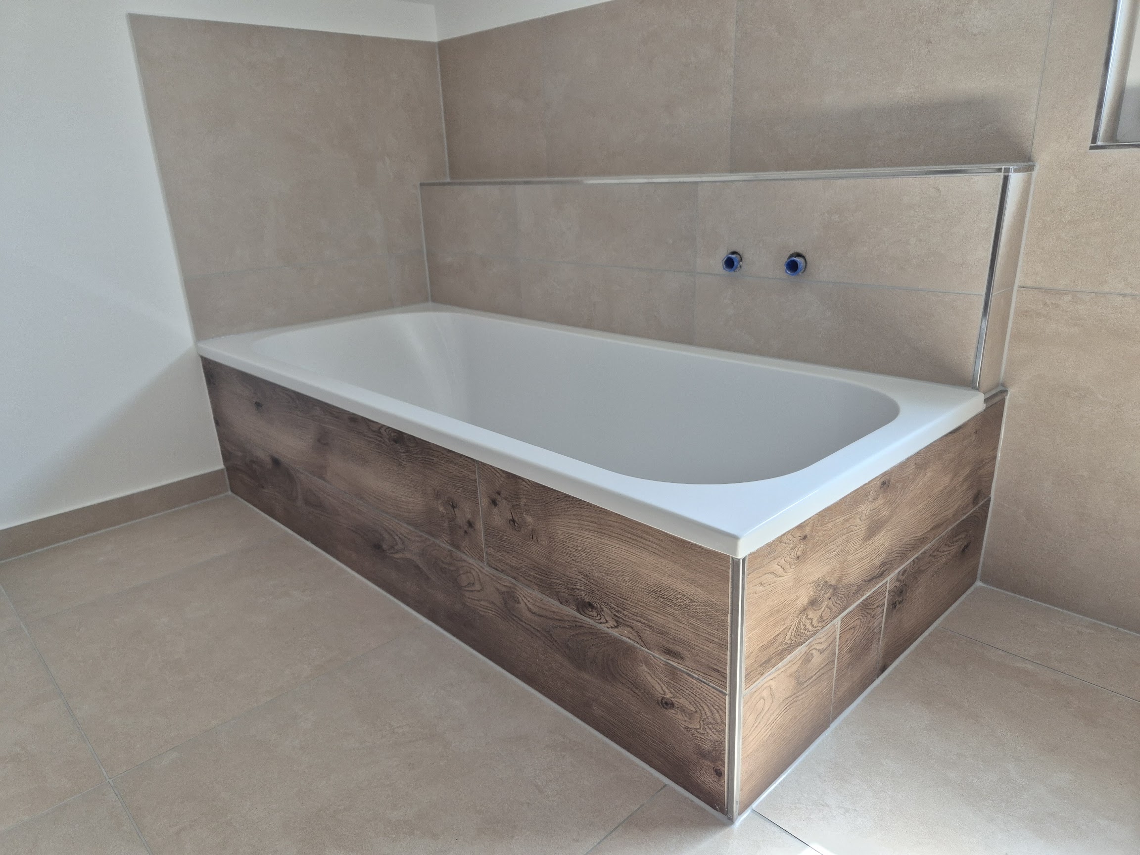 Eingebaute Badewanne mit Fliesenverkleidung in Holzoptik